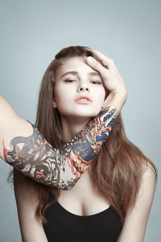 Girl and male hand with a tattoo on her face | portrait, model, girl, natural make-up, long hair, light-brown hair, male hand, tattoo, black top, background