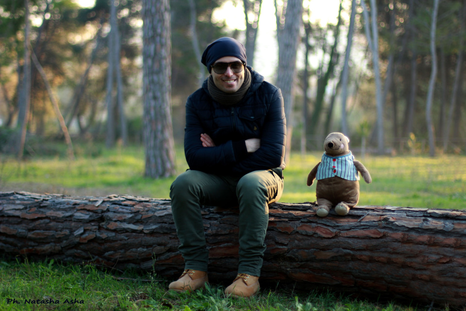 Man and teddy bear sitting on the log | portrait, model, man, forest, trees, teddy bear, sun glasses, smile, green grass, log