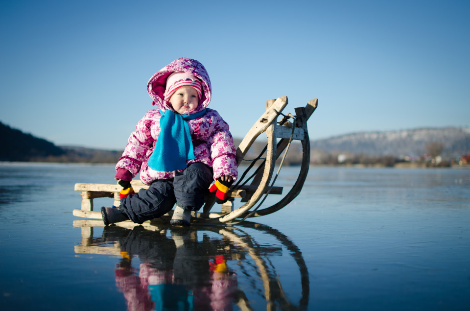 Child on the frosen lake | child, sledge, ice, winter, horizon, blue sky