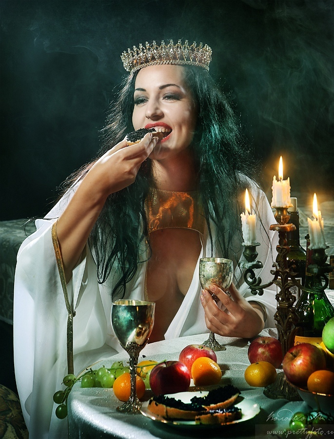 Beautiful woman in a crown eats black caviar | portrait, model, woman, fruits, long hair, brunette, crown, bowl, black caviar, candles
